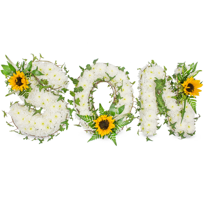 A three-dimensional memorial arrangement spells the word SON in uppercase form, captured on a clean white background to emphasise shape, texture and colour. Each letter is densely covered with small, pristine white chrysanthemums that form a pillowy, consistent surface; the flowers are layered so the letters read clearly from a distance yet reveal delicate petal detail close up. Interlaced through the white base are lengths of dark green ivy, their characteristic lobed leaves and trailing stems wrapping gently around each letter to create movement and a sense of ongoing life. Interspersed among the ivy are lighter green fern fronds and pointed leaf tips which provide contrast, shadow and definition in the curves and angles of the O and N. Three large sunflowers provide focal accents: a sunflower sits on the S's upper left loop, another is placed at the lower inner curve of the O amidst the ferns, and a third adorns the upper right stroke of the N; their vivid yellow petals radiate outward from warm, dark brown centres, bringing a hopeful brightness to the predominantly white-and-green composition. The photographic light is neutral and even, showing the chrysanthemums' soft texture, the ivy's glossy highlights and the sunflower centres' coarse detail. This tasteful combination of white blooms for peace, evergreen foliage for continuity and sunflowers for warmth makes the tribute particularly appropriate for memorial services in Epping near St John's Church, Bell Common or beneath the trees of Epping Forest, and it is often chosen by families seeking a personalised floral tribute for a son.