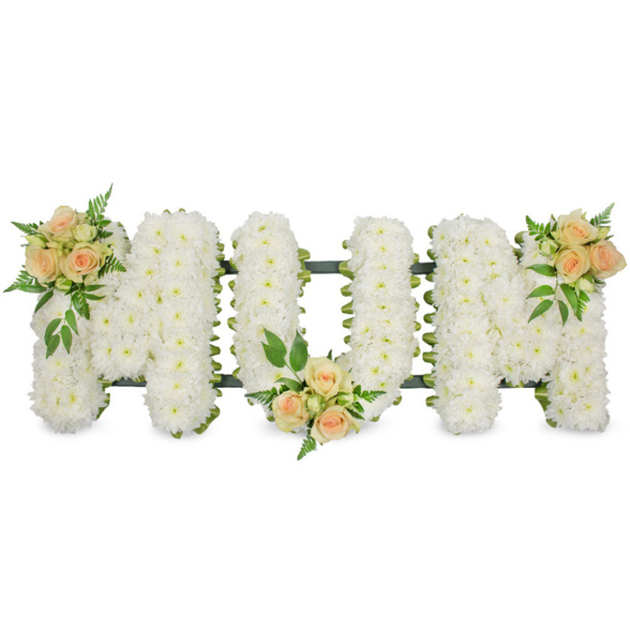 This image features an elegant MUM funeral tribute, photographed head-on so that the three floral letters appear in a straight horizontal line against a pure white backdrop. The letters themselves are crafted entirely from closely packed white spray chrysanthemums, each bloom about the size of a coin, with layered petals that give a soft, cushion-like finish. The chrysanthemums are arranged so tightly that no gaps of foam are visible, only the occasional glimpse of the supporting dark green frame and ribbon edging that neatly outlines the shape of each letter. Along the top left of the first M, the lower centre of the U, and the top right of the last M, the white expanse is gently broken by clusters of roses in muted peach and blush tones. These rose groupings include both firm buds and partially opened blooms, their velvety petals curved inwards like little shells. Around them, a halo of foliage - from lacy fern fronds to slightly broader, darker green leaves - adds a natural, garden-like softness and a rich contrast to the white chrysanthemum base. The overall lighting is even and bright, enhancing the clean, fresh look of the flowers and making the tribute easy to imagine placed lovingly on a casket or beside a memorial display in an Epping church or at a local crematorium. This MUM arrangement speaks quietly of love, gratitude, and cherished memories, offering a peaceful and respectful way for families in and around Epping to honour a special mother's life and say a gentle goodbye.