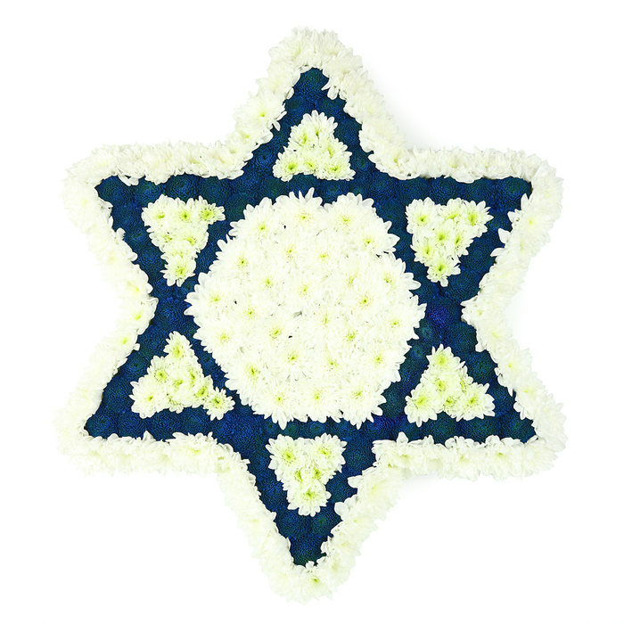 A carefully designed Star of David floral tribute dominates the scene, rendered in crisp white and deep blue flowers that stand out clearly against a bright, uncluttered white background. The six-pointed Jewish star is perfectly proportioned, each point outlined with a generous band of white chrysanthemums packed so tightly that they form a soft, quilted border. Their small petals overlap like layers of delicate tissue, giving the outer edge a feathery, yet structured feel, as if the star were cushioned on a bed of snow. Within this border, the florist has created a clean central hexagon of matching white blooms, its surface even and luminous, suggesting purity and peace at the heart of the piece. Radiating outwards, the six points of the star are filled with a dense field of dark blue flowers, possibly navy chrysanthemums or carnations, their saturated colour and slightly ruffled petals adding depth and a quiet gravity. At the inner base of each point, a neat white triangle is set into the blue, repeating the central tone and creating a subtle, geometric pattern that feels both modern and deeply symbolic. The interplay of blue and white recalls the colours of the tallit and Israeli flag, grounding the tribute in Jewish heritage and tradition. Imagined as created by experienced florists in Epping for a local Jewish funeral, memorial at the cemetery, or shiva house near the town centre or St John's Road, this design communicates respect, continuity of faith, and heartfelt remembrance. It appears fresh, balanced, and thoughtfully composed, intended to rest beside a coffin, memorial stone, or photograph as a final, dignified farewell.