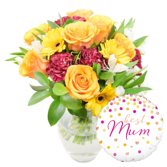 A rich and celebratory floral composition sits against a pristine white background, artfully staged to highlight texture, colour, and sentiment. Prominent peachy-orange and sunlit yellow roses anchor the arrangement, their rounded, velvety petals layered in classic spirals that catch light and suggest both elegance and comfort. Bright yellow gerbera daisies punctuate the scene with their broad, cheerful faces and deep-centre contrast, while ruffled burgundy carnations build volume and a sumptuous, tactile shadow-play among the blooms. White alstroemeria with slender petals and faint freckling weave delicately through the warmer tones, offering a refined, almost lyrical accent. A plentiful underlayer of glossy green foliage-smooth broad leaves and narrow sprigs-gives structure and a breath of freshness, and the clear glass vase reveals the crisscrossed stems and clean water inside, a quiet testament to careful conditioning and florist technique.

To the lower right, overlapping the base of the vase, a round white foil balloon adds a playful flourish. It is festooned with scattered gold and fuchsia dots and small heart motifs, and the centre reads best Mum in an elegant, flowing fuchsia script that feels personally written. The overall effect is warm and thoughtful, the sort of bouquet-and-balloon pairing one might send to a mother after a walk in Epping Forest or a relaxed morning coffee on Epping High Street-a present that says appreciation, celebration, and homegrown affection.