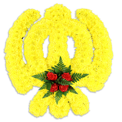 A reverent floral tribute shaped with care into the distinctive Khanda emblem sits against a pure white background, its symbolic lines artfully realised in an abundant carpet of small, bright yellow chrysanthemum blooms. The circular chakram, the two curved kirpans, and the central double-edged khanda sword are all suggested through the careful placement of the sunlit yellow petals, producing a slightly raised, sculptural texture that reads as both ceremonial and tender. At the very heart of the Khanda a concentrated cluster of five to six deep red roses is arranged like a silent focal prayer; their velvety petals are cushioned by dark green fern leaves that frame the roses and heighten the chromatic contrast. The lighting is soft and even, allowing the yellow to glow warmly while a gentle grey shadow beneath confirms the arrangement as a substantial, physical piece - suitable for remembrance services, Sikh religious ceremonies, or commemorative events held at local gurdwaras and community halls across Epping and neighbouring Theydon Bois or Loughton. As florists in the town, Flowers Epping craft such emblems with attention to symbolic accuracy and floral longevity, selecting freshly opened chrysanthemums for density and roses for a dignified centre. The bouquet carries a subtle floral scent - a sweet, clean chrysanthemum note underlined by the rose's classic aroma and the green freshness of fern. This piece speaks of respect and solidarity, hand-constructed to honour heritage and to provide a calm, beautiful presence during moments of remembrance or cultural gathering.