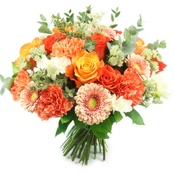 This bouquet feels like a hand-held sunbeam set against a brilliant white sheet: a classic, rounded hand-tied arrangement whose warmth and texture are immediate. At the heart sit several large roses - some glowing with deep, molten orange, others in a clear, golden yellow - their velvety petals unfurling in tight spirals that give off a subtle, intoxicating rose scent. Interlaced among them are plentiful coral and peach carnations, their ruffled, multi-layered petals creating soft, tactile islands that invite touch. Bright gerbera daisies offer playful punctuation with wide, delicate petals in apricot and peach, each centered by a gentle green eye that draws the gaze inward. Scattered white accent blooms, reminiscent of freesia or small spray flowers, provide crisp highlights that lift the warm palette, while airy pale-green filler clusters - Astrantia-like in their fineness - add delicate, feathery texture. Silvery eucalyptus leaves, rounded and slightly glaucous, thread through the bouquet, cooling the composition and releasing a clean, camphorous note when handled. The stems are tightly gathered and tied, signalling careful floral construction and freshness, ideal for display on a dining table in Epping or as a bright gift delivered locally from a neighbourhood florist. The overall impression is cheerful and composed: a bouquet that reads as celebration, consolation, and everyday beauty all at once, perfect for birthdays, thank-you gestures, or bringing seasonal joy into a home near the station or along the High Street.