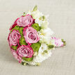 Laid gently on a neutral, light beige fabric that resembles finely woven linen, this bouquet looks as though it has been placed down for a quiet moment before an Epping wedding begins. The central focus is a gathering of lush pink roses, their petals layered thickly and curling outwards, shifting from a soft, powder-pink in the depths to vivid fuchsia edges that add drama and depth. Nestled closely between them are tidy globes of lime green button chrysanthemums, their compact, bumpy texture contrasting with the velvet smoothness of the rose petals and injecting a fresh, modern twist into the classic bridal palette. On the right side, a mist of white lisianthus spills outward, some blooms fully open with ruffled, almost cloud-like petals, others in elegant, elongated buds tinged with cream. This mix of stages lends a sense of movement and life, as if the bouquet is still gently unfolding. The stems are expertly bound into a neat handle wrapped in pale blush satin, smooth and softly reflective. Coiled around the ribbon, slender strands of white pearls trace delicate lines, offering a hint of vintage elegance that would feel perfectly at home in a ceremony near Epping High Street or a reception overlooking the green spaces around the town. The composition is carefully balanced yet relaxed, the colours flowing from vibrant to tranquil. It evokes the sensation of soft fragrance, rustling petals, and the quiet anticipation before vows are spoken, making it a fitting visual for wedding floristry, bridal features, or romantic celebrations across the Epping area.