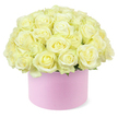 A luxurious cluster of cream and white roses billows from a pastel pink hat box, forming a flawless, rounded dome that seems to overflow with petals against a pristine white background. Each rose head is generously open yet still fresh, with velvety petals arranged in tight spirals, their outer edges a soft ivory that gradually deepens towards centres brushed with the lightest touch of pastel yellow, like early sunlight caught in the heart of each bloom. The roses are massed so closely that their petals meet and gently press together, creating a plush, almost quilted texture that draws attention to their abundance and uniform beauty. Here and there, tiny hints of green foliage are visible at the base, serving as a subtle frame that reinforces the natural origin of the arrangement without disturbing the calm, tonal harmony of cream and blush. The cylindrical hat box is a pale, romantic pink with a smooth, matte surface, the kind of tactile finish that suggests careful craftsmanship and a considered choice of materials. Its simple, contemporary profile complements the classic character of the roses, embodying the blend of tradition and modern style that many couples in Epping seek for anniversary flowers or intimate celebrations at home. The bright, even lighting ensures that every layered petal and gentle curve is clearly defined, while the absence of background clutter keeps the focus firmly on the composition itself. This image conveys a sense of indulgence, tenderness, and thoughtful design, ideal for representing refined anniversary gifts or romantic flower deliveries around Epping and the surrounding villages.