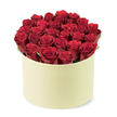 An exquisitely lush arrangement of dozens of deep red roses, presented in a round cream gift box with a soft, matte finish. The roses form a dense, glossy dome that fills the container, their heads tightly furled into perfect symmetry, as if newly opened and ready to scent the room. Between the blooms, hints of dark green foliage peek out, adding natural depth and life to the scene. The pale cream box itself carries a refined, hat-box elegance, its round shape and smooth surface suggesting a premium, gift-worthy moment. The image is set on a clean white background, allowing the color and texture to speak with quiet confidence. Light traces the velvet edges of the petals and throws a delicate shadow along the rim, accentuating the bouquet's generous scale.

This is romance in its most timeless form: a thoughtful gift perfect for Valentine's Day, anniversaries, or any celebration that calls for elegance and care. It speaks of craftsmanship-the sort you can trust from a skilled local florist in Epping-delivered with reliability to homes across the town and nearby villages. Flowers Epping often crafts statements like this, combining classic beauty with modern ease so you can share a moment of grace with someone special.