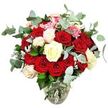 The photograph captures a sumptuous rose bouquet that looks as though it has just been arranged on a workbench in an Epping florist's studio, then placed before a spotless white backdrop so every hue and detail can be appreciated. The flowers are presented in a clear glass vase with a rounded bottom and a gently narrowing neck, through which straight, freshly cut stems are visible, submerged in clear water that underlines their freshness. Above this simple base, the bouquet rises into a perfectly rounded, abundant display dominated by rich red and scarlet roses. Their petals have a velvety texture and unfurl in soft spirals; some blooms are wide open, revealing intricate hearts, while others remain tight buds, suggesting romance that continues to unfold. Nestled among the reds are creamy white and softly ivory roses, along with a few white blooms edged with a delicate pale pink, bringing a serene contrast and a feeling of tenderness. Small clusters of bright pink filler flowers, likely mini carnations or similar petite blossoms, peek out from between the rose heads, lending lightness, movement, and a playful accent. Flowing throughout the arrangement are blue-green eucalyptus sprigs with rounded, slightly powdery leaves, their cool tone and natural fragrance echoing the calm, leafy paths of nearby Epping Forest. Dark green foliage and discreet silvery leaves frame the design, filling every gap so the bouquet appears lush, complete, and professionally composed. With its clean white setting, this arrangement reads as a classic symbol of love and celebration, perfectly suited for romantic deliveries across Epping-whether sent to mark an anniversary, a milestone birthday, or a heartfelt 'I love you' from afar.