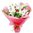 The photograph presents a stunning, professionally arranged bouquet where pure white Oriental lilies and deep red roses are gathered into a joyful, gift-ready display. The lilies sit proudly towards the top and centre, their large, trumpet-shaped blooms fully open to reveal smooth, luminous petals surrounding dark, pollen-heavy stamens that offer a rich contrast. Some flowers remain as tightly held buds, coloured in soft shades of pale green and ivory, suggesting freshness and longevity, as if the bouquet has just been prepared in a studio near Epping Station for same-day delivery. Between the lilies, red roses are tucked in thoughtfully, their petals rich and velvety, some still in bud and others beginning to spiral outward, adding a romantic intensity and a hint of classic charm. Around them, generous foliage in deep shades of green frames the flowers-broad, shiny leaves provide a solid, structured backdrop, while spiky, grass-like blades create light, airy movement, echoing the natural greenery that surrounds the Epping area and the edge of the forest. The entire arrangement is cradled in a bright pink, glossy wrapping, likely cellophane or floral film, folded in soft, voluminous waves that catch and reflect the light, giving the bouquet a festive, almost celebratory glow. A slim lime green satin ribbon is tied neatly at the base, its fresh, citrusy hue enhancing the greens of the leaves and adding a playful twist to the colour palette. This bouquet radiates warmth and affection, ideal for marking milestones, cheering up a friend on a rainy day in Epping, or sending a tender message when you cannot be there in person.