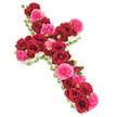 Against a clean, bright white backdrop, a lavish floral cross is shown in full detail, its colours vivid yet composed, evoking a quiet, reverent atmosphere. The entire cross is constructed from an abundance of fresh roses, with the flowers placed so closely together that they create an almost fabric-like surface of petals. Deep, velvety red roses take the lead, forming the main vertical and horizontal structure and drawing the eye along the simple, powerful lines of the cross. Mixed among these rich crimson blooms are clusters of fuchsia pink roses and garden-style roses, whose slightly softer, more ruffled petals bring brightness and gentle contrast, reminiscent of cheerful window boxes and gardens around Epping's residential streets. Smaller rosebuds in complementary shades of red and pink tuck themselves between the open flowers, creating a textured undercurrent that suggests layers of shared memories and stories. The outline of the cross is finely edged with a narrow band of small white blossoms, such as spray chrysanthemums or delicate carnations, which form a luminous border separating the bold colours from the pale background. Occasional hints of fresh green foliage and slender leaf tips appear along the edges, giving a subtle sense of natural movement and life. The lighting is soft and evenly distributed, illuminating the roses without glare and preserving the crispness of the white edging. This refined floral cross feels like a thoughtful, professionally arranged sympathy tribute, suitable for a funeral service in Epping or a memorial gathering in the surrounding countryside, offering a graceful expression of faith, remembrance, and quiet comfort to family and friends.