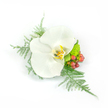 A delicate white Phalaenopsis orchid anchors this refined corsage, its broad satiny petals unfurling with a quiet, waxy sheen and a soft yellow-gold throat that warms the bloom's pure white surface. The orchid sits slightly off-centre, framed by wisps of feathery asparagus fern that lean like tulle and lend an airy, almost breathlike motion to the piece. Beside the flower, clusters of glossy, reddish-pink hypericum berries catch light and introduce a gentle pop of warm colour, while a compact, lime-green chrysanthemum or textured filler nestles low, offering a fresh, verdant contrast. The composition is compact and asymmetrical - balanced yet lively - designed to be pinned to a lapel or worn as a wrist corsage for weddings, proms, or formal gatherings. The clean white background highlights every textural detail: the orchid's smooth petals, the fern's fine filaments, the berries' sheen, and the chrysanthemum's almost succulent fuzz. Imagine the faint green scent of cut foliage and the faintly sweet, neutral aroma of orchid petals in soft morning light; the overall impression is serene, celebratory, and thoughtfully composed. As a florist's piece, it reads as both modern and timeless, intended to sit lightly against fabric and to provide a tactile memory of a special day. The styling and precise pinning show professional craft - each element chosen for contrast, durability, and comfort - creating a small floral sculpture that feels intimate and elegantly restrained, suitable for brides, ushers, or anyone seeking quiet sophistication for a moment worth remembering.