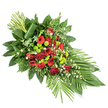 The photograph presents a long, elegant red and green funeral spray laid out on a stark white background, allowing each petal and leaf to be clearly seen, as if the tribute has just been arranged by a careful florist in Epping. The arrangement is shaped into an elongated teardrop, full and abundant at one end and narrowing to a soft, pointed tip, giving it a sense of gentle movement and direction. Deep red roses, some fully open and others still in bud, form the emotional centre of the spray, joined by bold red gerbera daisies and frilled red carnations that echo their passionate tone. Interspersed between these crimson flowers, bright lime-green button chrysanthemums provide a striking, contemporary contrast, their round, compact heads adding a playful yet refined texture. Light touches of tiny white blooms, resembling dainty daisies or gypsophila, are scattered throughout, bringing lift and softness, almost like glimmers of light amid deeper shades. A lush mass of foliage frames the flowers, with broad, glossy dark green leaves, delicate fern fronds, and other textured greens combining to create depth and a natural, woodland feel that calls to mind the calm edges of Epping Forest. On the lower right, several long, sleek leaves fan outward, reinforcing the graceful sweep of the design, while at the upper left, a tidy cluster of tall stems stands upright, encircled at the base by a single wrapped leaf for a crisp, modern accent. Thoughtfully arranged, this dignified spray is perfectly suited as a casket adornment or funeral tribute for services held in and around Epping, conveying deep sympathy and quiet strength.