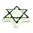 Displayed against a spotless white backdrop, this floral tribute presents a bold, six-pointed Star of David crafted with the precision of an experienced funeral florist. The structure is entirely formed from small, many-petalled flowers, densely placed to create a continuous, cushion-like surface that appears soft and gently textured to the touch. A broad band of pure white blossoms traces every outer edge of the star, while the central hexagon glows with the same clean white, evoking a sense of purity and spiritual calm often sought at Jewish funerals in and around Epping. Interlaced through this are two sharply defined triangles, filled with deep navy blue blooms that establish the unmistakable form of the Magen David. The blue sections are rich and velvety, standing in clear contrast against the white and giving the symbol both visual strength and emotional weight. Six smaller triangles of white bloom point inward from the tips, adding dimensionality and suggesting subtle movement, as if the star is quietly radiating from its centre. The strict blue-and-white palette gently echoes the Israeli flag, reinforcing cultural and religious identity without overpowering the composition. The flowers are uniform, fresh, and expertly aligned, with no greenery or decorative extras to distract from the sacred emblem they create. This thoughtful design would feel at home in a synagogue service, a chapel of rest, or a shiva house near Epping Forest, offering a serene and respectful expression of sympathy, remembrance, and enduring Jewish heritage.