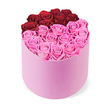 A vibrant floral display unfolds in a light pink, matte round cylindrical gift box, filled to the brim with roses arranged to form a striking heart across the top. The heart's upper lobes are composed of about a dozen deep, rich red roses, tightly clustered into a dramatic curve. The lower portion, forming the heart's point, is filled with many soft blush pink roses, creating a two-tone, romantic motif. Each rose sits full and perfectly bloomed, its petals tightly folded to produce a plush, uniform texture across the surface. The box, set against a pure white background, highlights the bold colour contrast and the bouquet's meticulous craftsmanship. This luxurious rose box conveys romance, celebration, and affection, making it ideal for Valentine's Day features, anniversary gifts, or romantic gestures. It also signals premium delivery services, particularly for luxury flowers in Essex towns like Epping and the surrounding communities. The bi-color arrangement in pink and red letters a timeless message of love and appreciation, ready to brighten a special day with a sense of soft, two-toned magic.