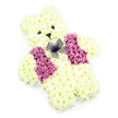A tender teddy bear floral tribute is pictured against a plain white background, its gentle form shaped entirely from fresh blooms that evoke the innocence of childhood. The bear's body, from its rounded head and small ears to its stout little legs and arms, is created from tightly packed creamy white chrysanthemums, each flower carefully angled to mimic the softness of fur. The petals appear almost cloud-like, giving the impression of a cuddly toy brought to life through flowers. On the face, two dark, button-style eyes and a small triangular black nose are nestled within the blooms, combining to give the bear a kind, watchful expression. Beneath the nose, a slight curve of petals suggests a quiet smile, adding a sense of reassurance and warmth. Draped neatly across the chest is a floral vest made from deep pink and magenta chrysanthemums, their richer colour tones standing out gently against the pale body. At the centre, just under the chin, a delicate bow of sheer purple netting sits like a tiny scarf, its gossamer texture adding an elegant finishing touch. The clean, white backdrop and soft, even lighting draw attention to every contour and detail of the design, from the crisp edges of each petal to the rounded outline of the bear's silhouette. This floral teddy is an especially moving choice for a child's funeral, a baby's memorial, or a quiet remembrance gathering in the Epping area, perhaps near local chapels or homes around Epping High Street, bringing solace and a sense of loving remembrance to difficult moments.